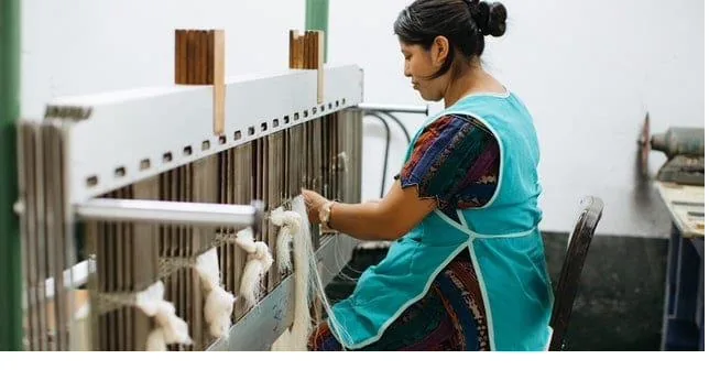 Weaver working a traditional loom with natural yarn