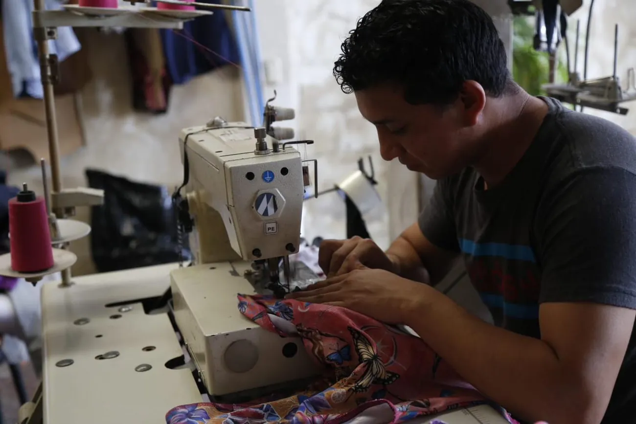 Operator sewing a printed activewear panel on an industrial machine